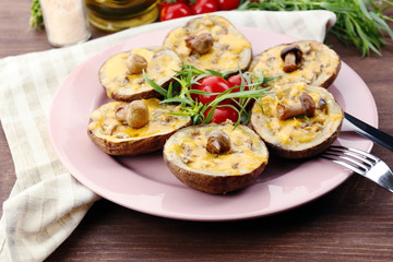 Baked potatoes with cheese and mushrooms on table close up