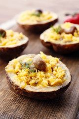 Baked potatoes with cheese and mushrooms on table close up