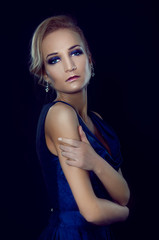Fototapeta premium Studio portrait of beautiful blonde woman in dark blue dress