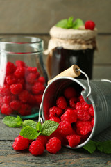 Sweet raspberries in decorative bucket on wooden  background