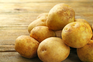 Young potatoes on wooden table close up
