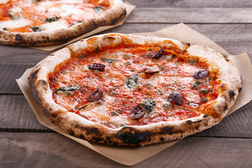 Delicious pizzas on wooden table, closeup