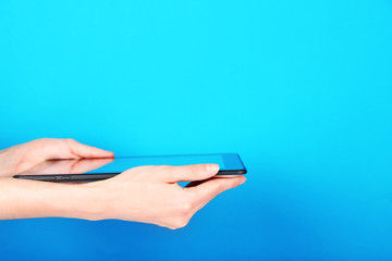 Female hands using tablet on blue background