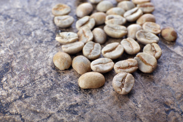 Heap of green coffee beans on table close up