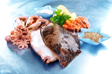 Fresh fishes and shrimps with spices  on metal background