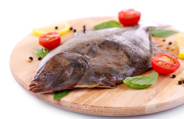 Fresh fishes with spices on cutting board close up