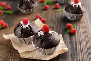 Delicious chocolate cupcakes with berries on table close up