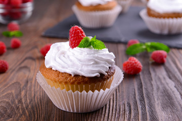 Delicious cupcake with berries and fresh mint on wooden table close up