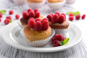 Delicious cupcakes with berries and fresh mint on wooden table close up