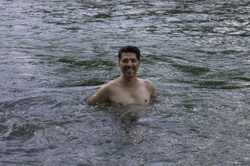 Mann steht in Strömung im Fluss
