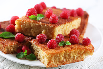 Fresh pie with raspberry in white plate on wooden table, closeup