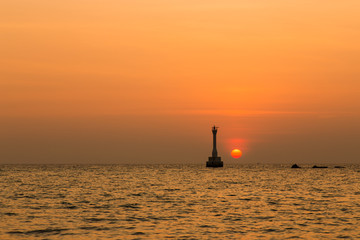 Silhouette of a lighthouse at sunrise.