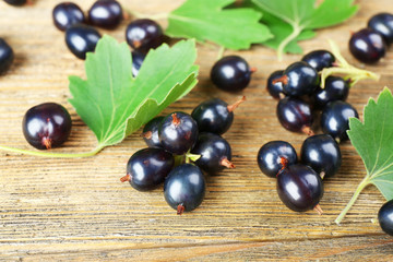 Ripe black currants on wooden background