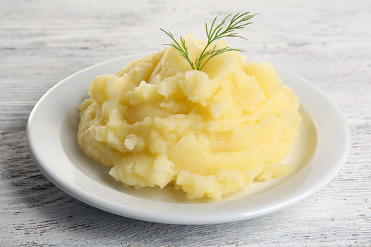 Mashed potatoes in plate on wooden table, closeup