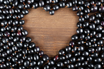Heap of wild black currant on wooden table close up