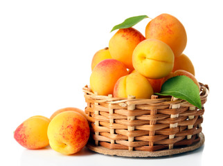 Ripe apricots in wicker bowl isolated on white