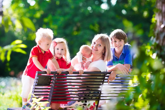 Family with kids relaxing on a park bench