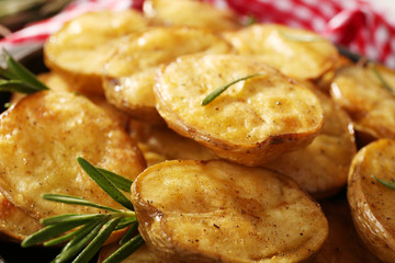 Delicious baked potato with rosemary in frying pan close up