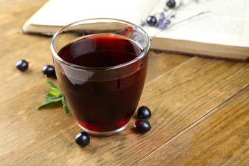 Fresh currant juice with berries and book on table close up