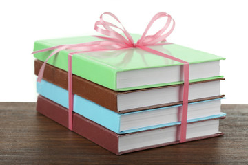 Obraz premium Stack of books with ribbon on light background