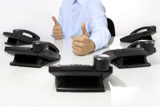 like hand with office phones on desk