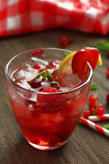 Glass of berry juice on wooden table, closeup
