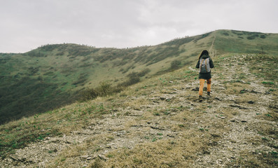 Hiker woman goes up in the mountain