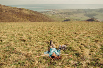 Fototapeta na wymiar Happy hiker woman lying on meadow