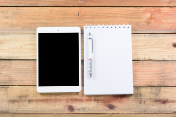 Tablet device on wooden workspace table