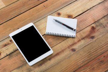 Tablet device on wooden workspace table