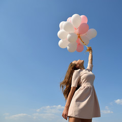 Fashion girl with  air balloons over blue sky