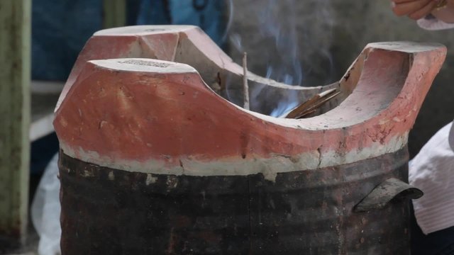 hand of woman trying to light on old charcoal brazier