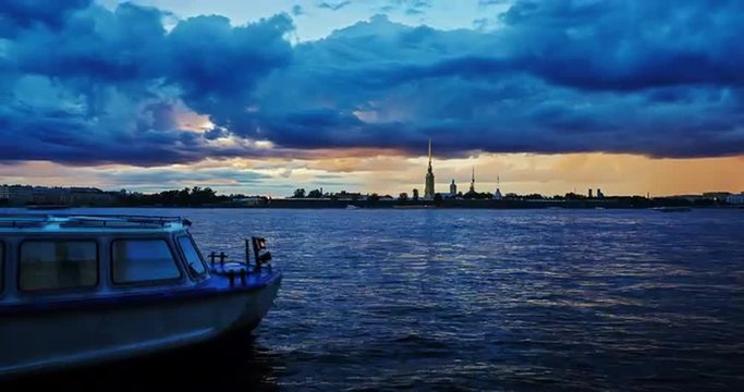 Russia, Saint-Petersburg, 02.08.2015: Time lapse Peter and Paul Fortress at sunset, boats, floating clouds, dark, turn on outdoor lighting, storm