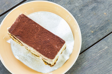 Tiramisu cake on wooden table background