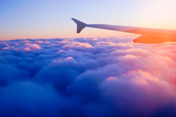 Fototapeta na wymiar Airplane Wing in Flight from window, sunset sky