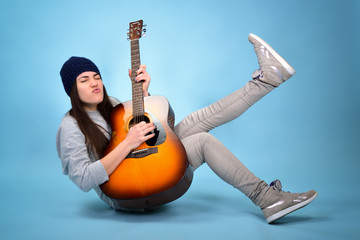 young woman playing music on acoustic guitar