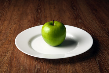 fresh green apple on a white plate
