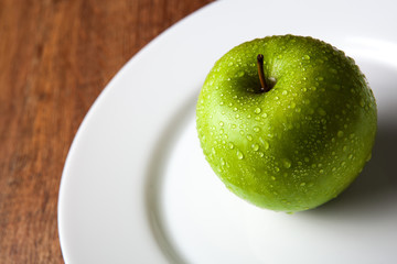 fresh green apple on a white plate