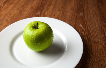 fresh green apple on a white plate