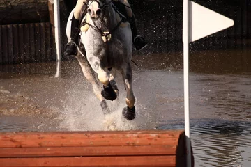 Keuken foto achterwand Paardrijden Horse at water jump.  Horse and rider at a water jump competing in an equestrian competition.
