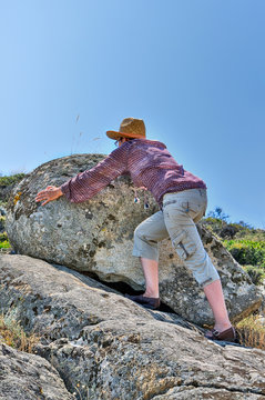
Woman moving the rock on the hill             
