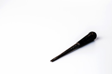 Old black screwdriver on white background
