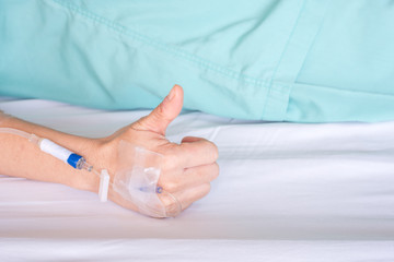 Hand of woman with drip in hospital bed