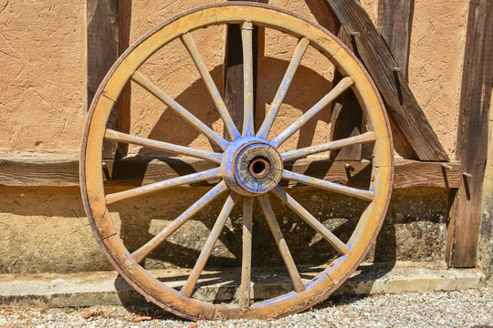 roue en bois contre mur habitation