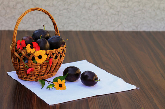 plums in a basket with flowers