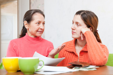 mother helps adult daughter  to fills in bills