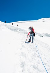 Female mountaineer ascending a glacier.