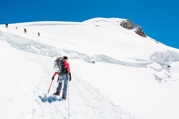 Naklejka na ściany i meble Female mountaineer ascending a glacier.
