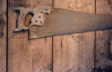 Vintage saw on the wooden grunge table with copy space