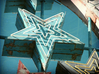 aged and worn vintage photo of neon sign stars